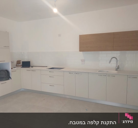מטבח חדש עם ארונות לבנים וכיור נירוסטה